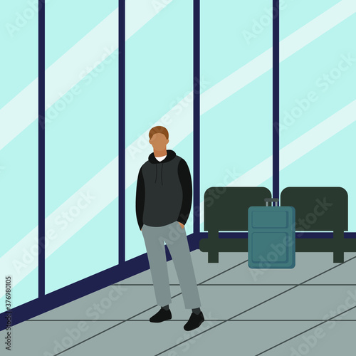 Young man with a suitcase in a waiting room