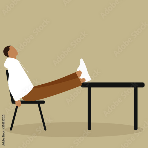 A man sits on a chair with his legs on the table