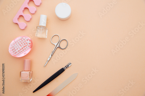 Nail care accessories. Professional steel manicure tools on pink background.