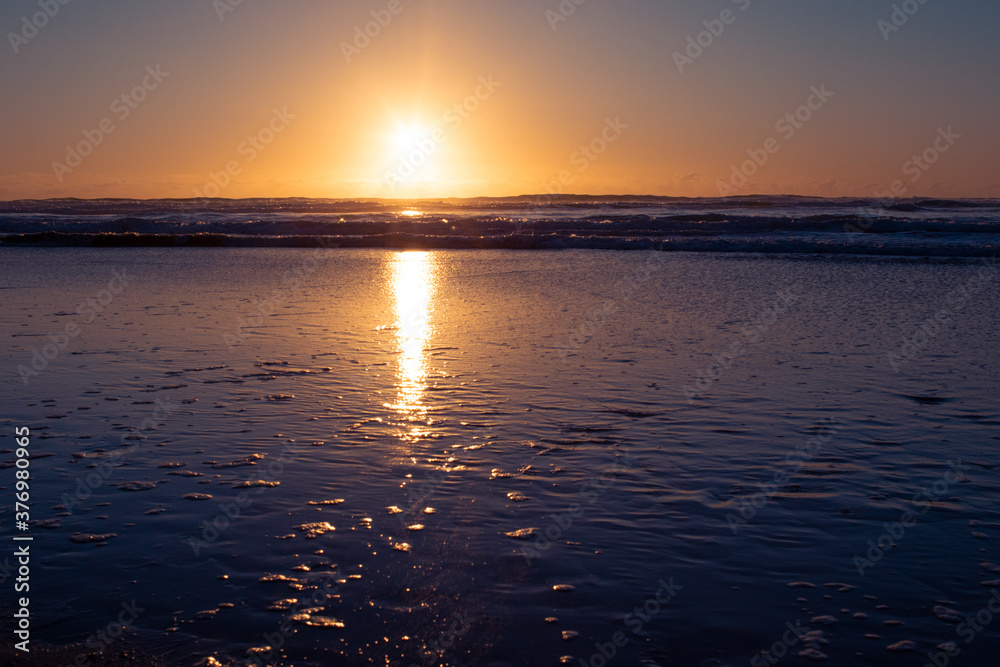 Naklejka premium Sonnenuntergang am Meer, schwarzer Sand