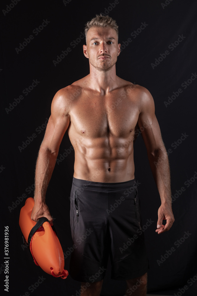 Portrait of a happy lifeguard on duty keeping a buoy Portrait of a happy lifeguard on duty keeping a buoy