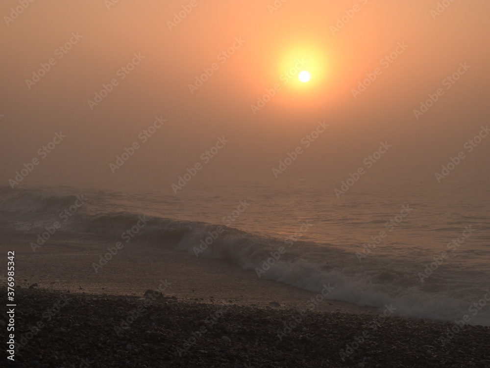 Sunset over the sea in fog