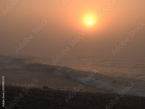 Sunset over the sea in fog