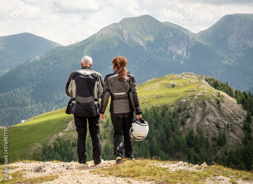 SOLKPASS, AUSTRIA - 08/13/2020: Couple of motobikers looking at mountains. photo