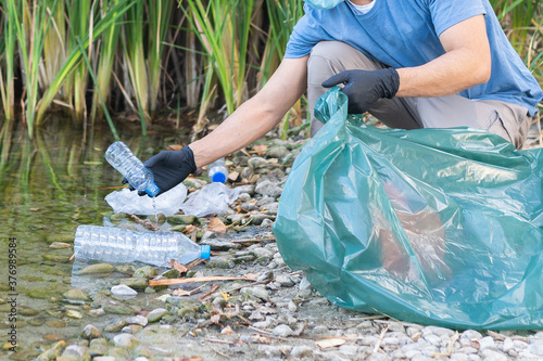 Close Up of Person Collecting Plastic From the River. photo
