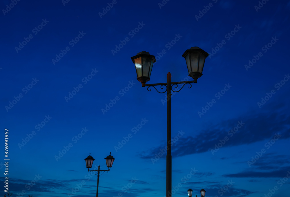 Old extinct street lamp at night. Two lanterns 