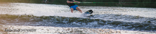 Man on a wakeboard in the river at daytime