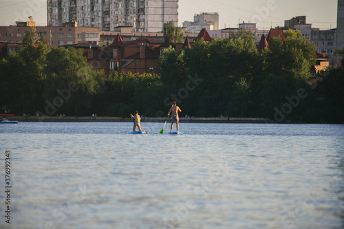 Couple on a SUP board in the river at daytime