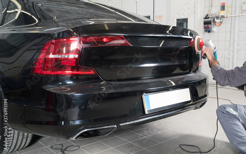 Automobile painting. Car painter with gun in chamber. Spray operation. 