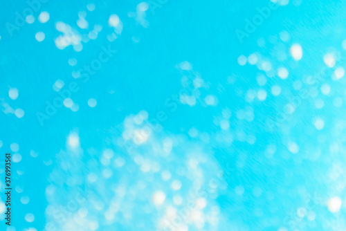 Obraz na plátne Snow spots are defocused on a heavenly background, scattered throughout the space unevenly, randomly