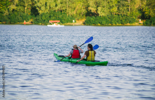 Couple paddling a kayak in the river at daytime