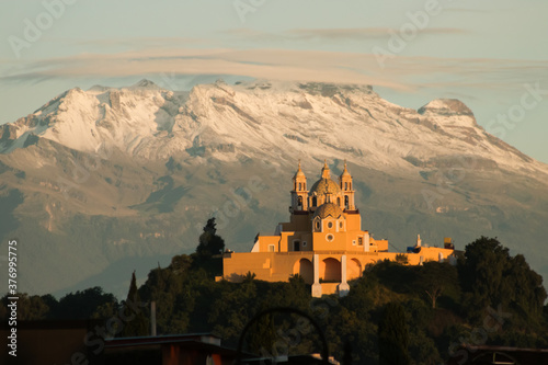 Remedios church and pyramid of cholula with iztaccihuatl volcano in the background at sunrise