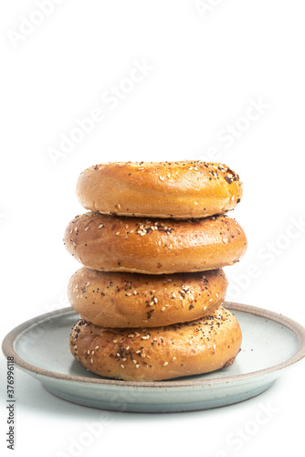 A Stack Of Four "Everything" Bagels On Ceramic Breakfast Plate