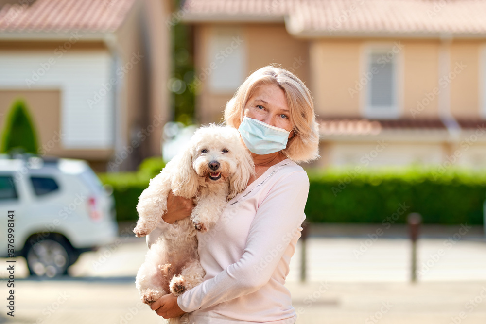 Portrait elderly woman with a dog outdoors an antivirus mask Portrait elderly woman with a dog outdoors an antivirus mask