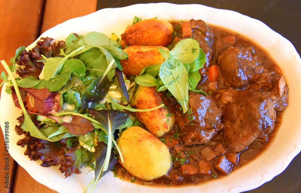 Rindergulasch mit Kartoffeln, grünem Salat und Soße mit ...
