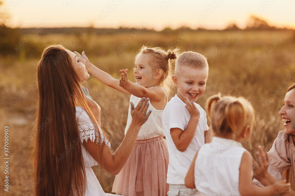 Fototapeta premium happy young moms playing with their kids outdoors in summer. Happy family time together concept. selective focus.