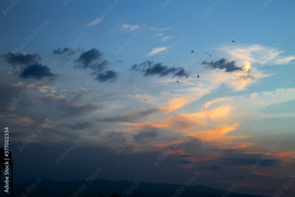 colorful sunset landscape with clouds and birds