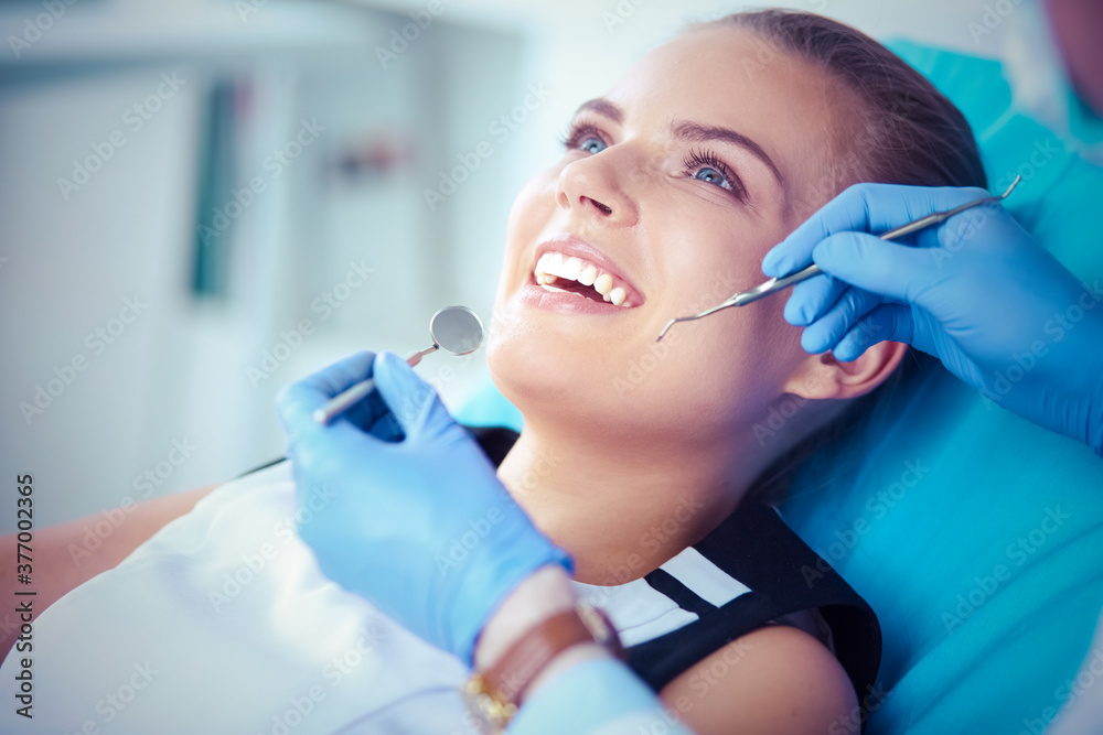 Young Female patient with open mouth examining dental inspection at dentist office. Young Female patient with open mouth examining dental inspection at dentist office.