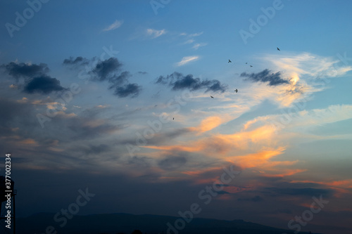colorful sunset landscape with clouds and birds