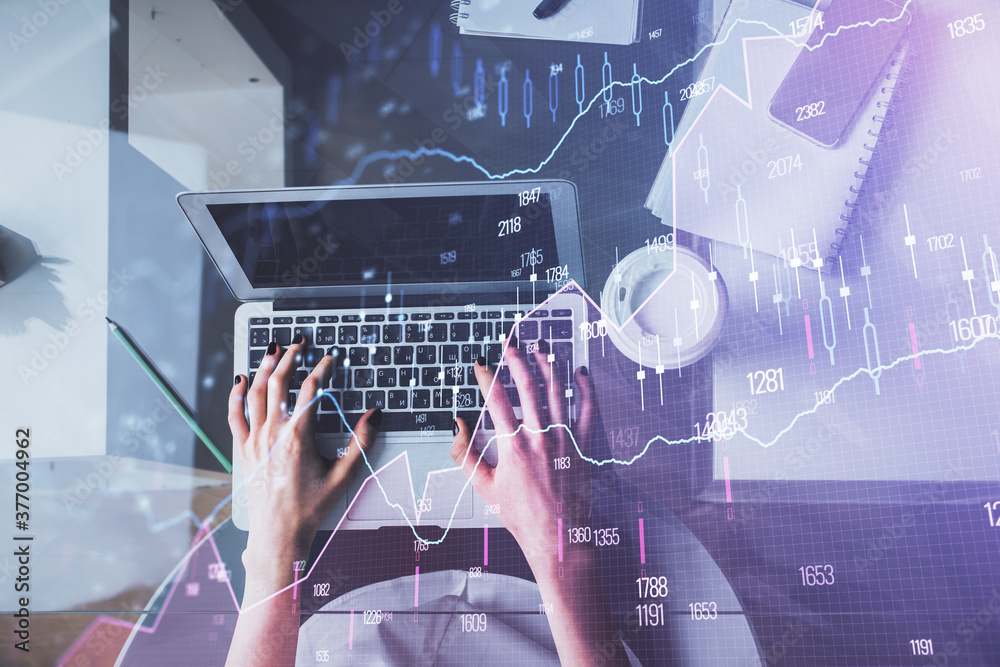 Double exposure of woman hands working on computer and forex chart hologram drawing. Top View. Financial analysis concept. Double exposure of woman hands working on computer and forex chart hologram drawing. Top View. Financial analysis concept.