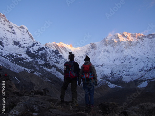 Mountain climbers gaze at the snow-covered Himalayas in the morning sun, ABC (Annapurna Base Camp) Trek, Annapurna, Nepal