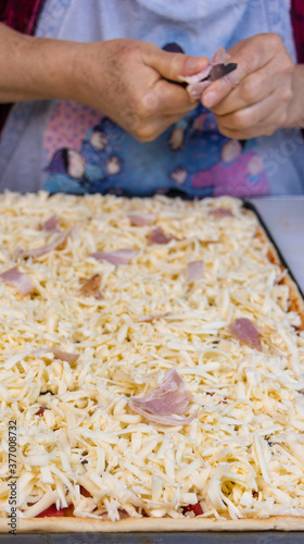 elderly woman white mother cutting sausages and sausages to make pizza