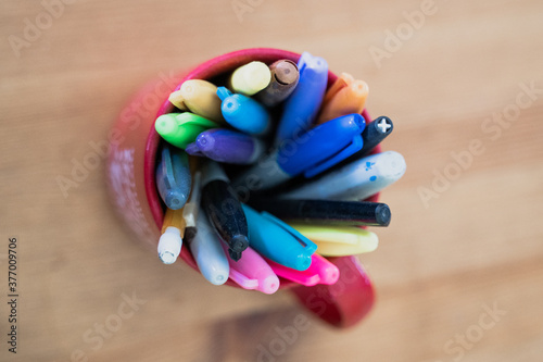 colored markers in a coffee cup