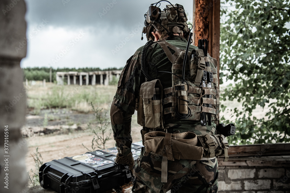 The soldier pulls a rifle out of the ammunition case and insert ammunition clip into assault rifle