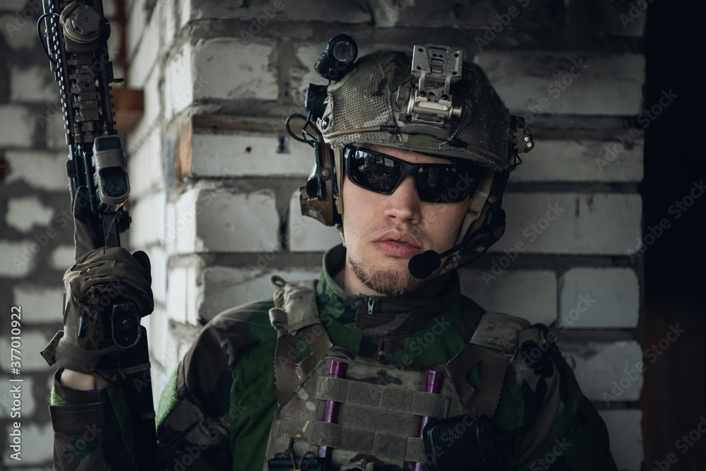 Close-up of a professional fully equipped soldier looking at camera. Close-up of a professional fully equipped soldier looking at camera.