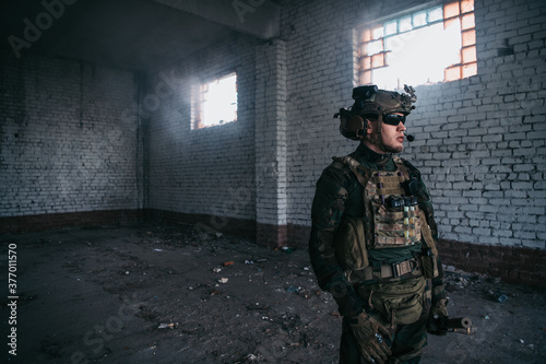 Front view close up of caucasian soldier with a rifle stand guard securing territory looking around.