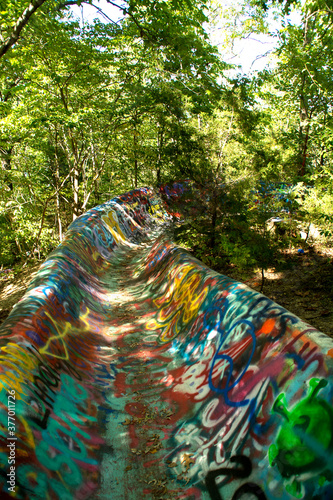 abandoned water slide graffiti in the woods