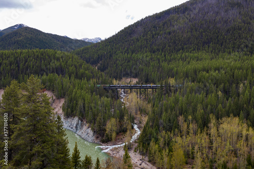 Railroad bridge over river with mountain background