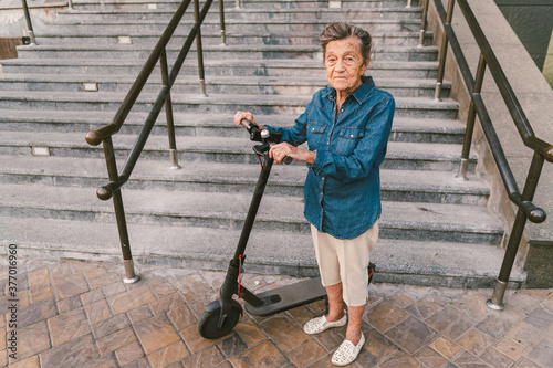 Old woman near scooter. Grandmother progressive woman. Senior having fun. Old woman enjoying her hobbies. Retired lady using modern clean transport. New generation. Mature woman loving her e scooter