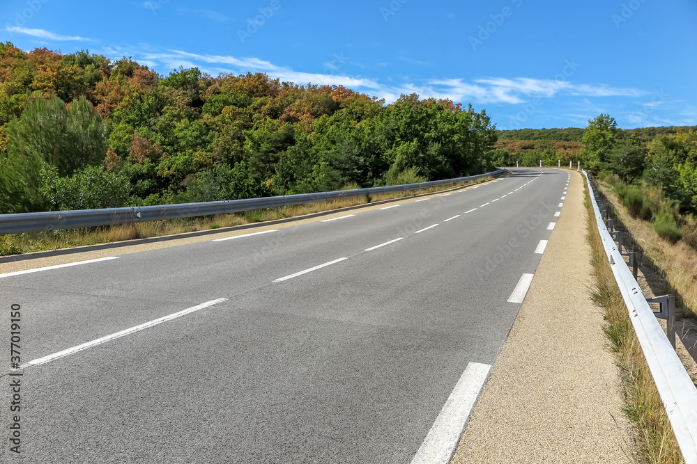 Regional road, with double lane and shoulder, crossing small forest, Provence-Alpes-Côte d'Azur region, Var, France