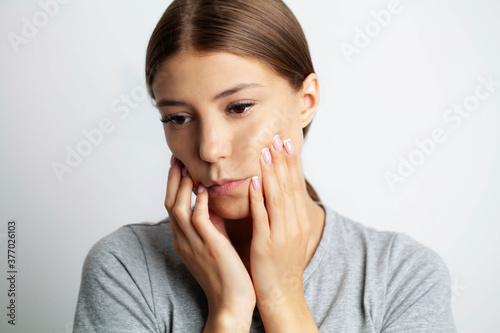 Close up of a beautiful young woman experiencing a painful toothache