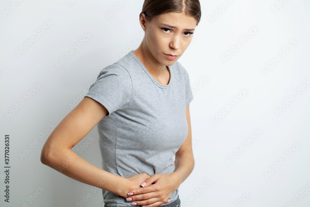 Young woman suffering from abdominal pain at home. Young woman suffering from abdominal pain at home.
