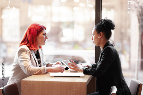 Two female business friends having a meeting at a cafe.