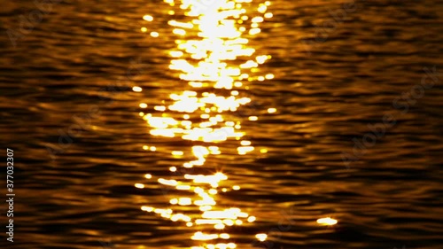 Close up of the water with a saturated sun reflection during a sunset