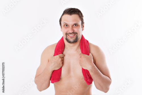the guy strokes his beard. morning treatments in the bathroom. blue towel around her neck. isolated on a white background. copy space