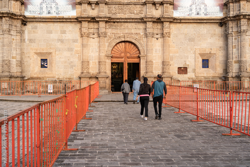 Dos parejas de adultos están caminando hacia la misa de la Basílica de Zapopan Jalisco.	