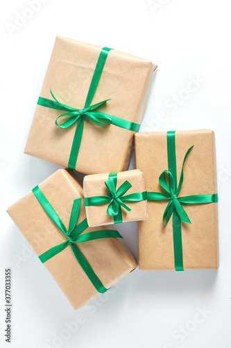 holiday concert. gifts wrapped in craft paper and tied with a green satin ribbon on a white background. space for text, flat lay