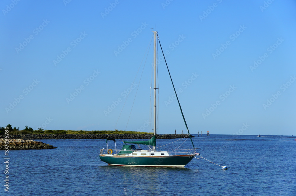 A green and white sailboat on the bay near Lewes, Delaware, U.S.A