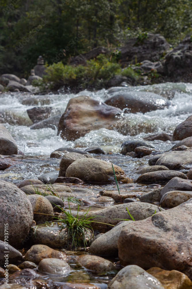 Green incense stick standing on a stone against the background of a running river Green incense stick standing on a stone against the background of a running river