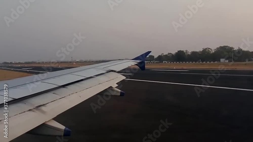 At the time of aircraft landing, the aircraft flaps are closing slowly on runway of  Nagpur , International airport.Close-up of the wing in the window. India