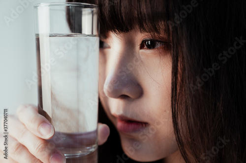 Close up shot of a girl and glass of water.