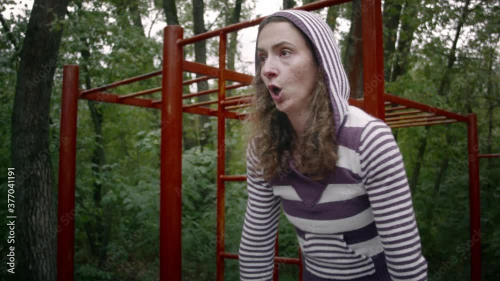 Young caucasian woman doing sports on the playground in the forest on a cloudy day. Woman doing abs exercises Young caucasian woman doing sports on the playground in the forest on a cloudy day. Woman doing abs exercises