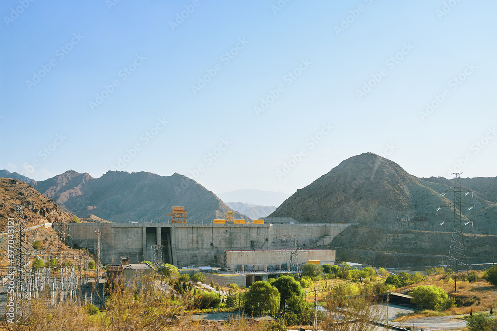 Obraz premium Dam in the mountains in Central Asia. View of a levee in the gorge.