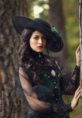 Beautiful brinette woman in historical dress and in hat, vintage style