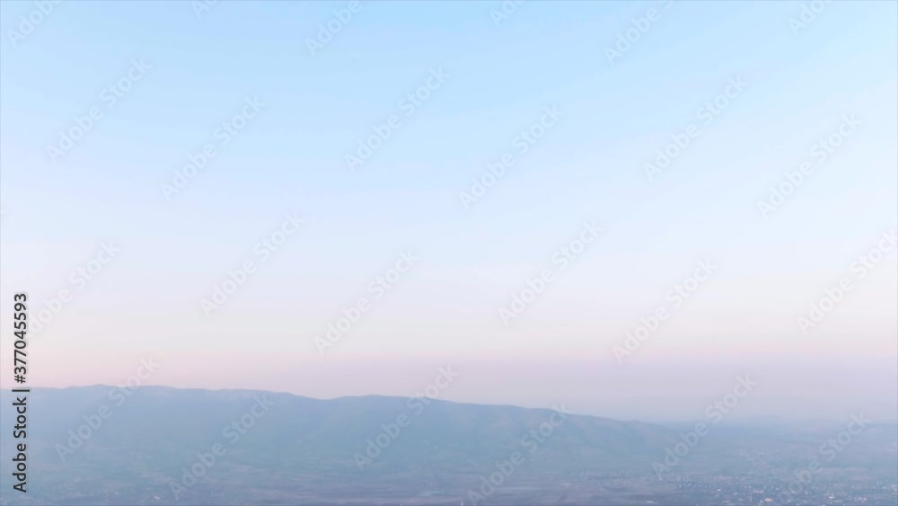 Camera pans down from a twilight sky to a town surrounded by mountains. Camera pans down from a twilight sky to a town surrounded by mountains.