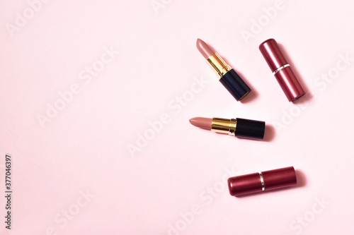 Several lipsticks on a pink background.Decorative cosmetics, make-up. space for text. top view.